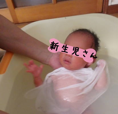 沐浴をする新生児の写真