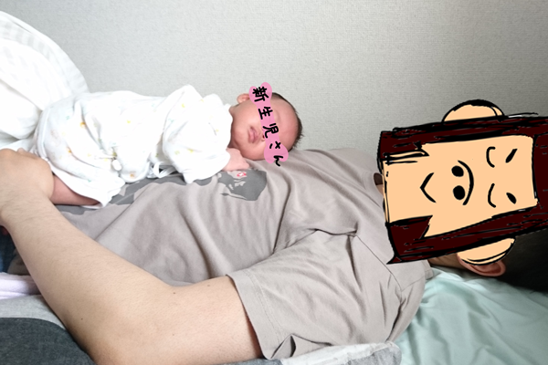赤ちゃんがパパの上で寝ている写真