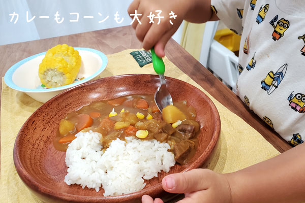 ホットクックで作ったカレーとトウモロコシを食べる子供